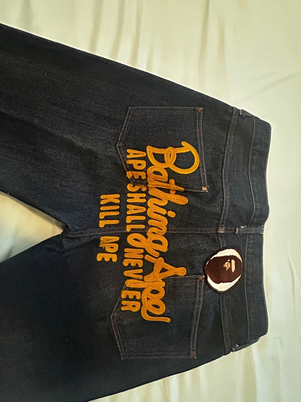 Bape Dark Blue Denim Jeans with Yellow Embroidered Script and Ape Patch